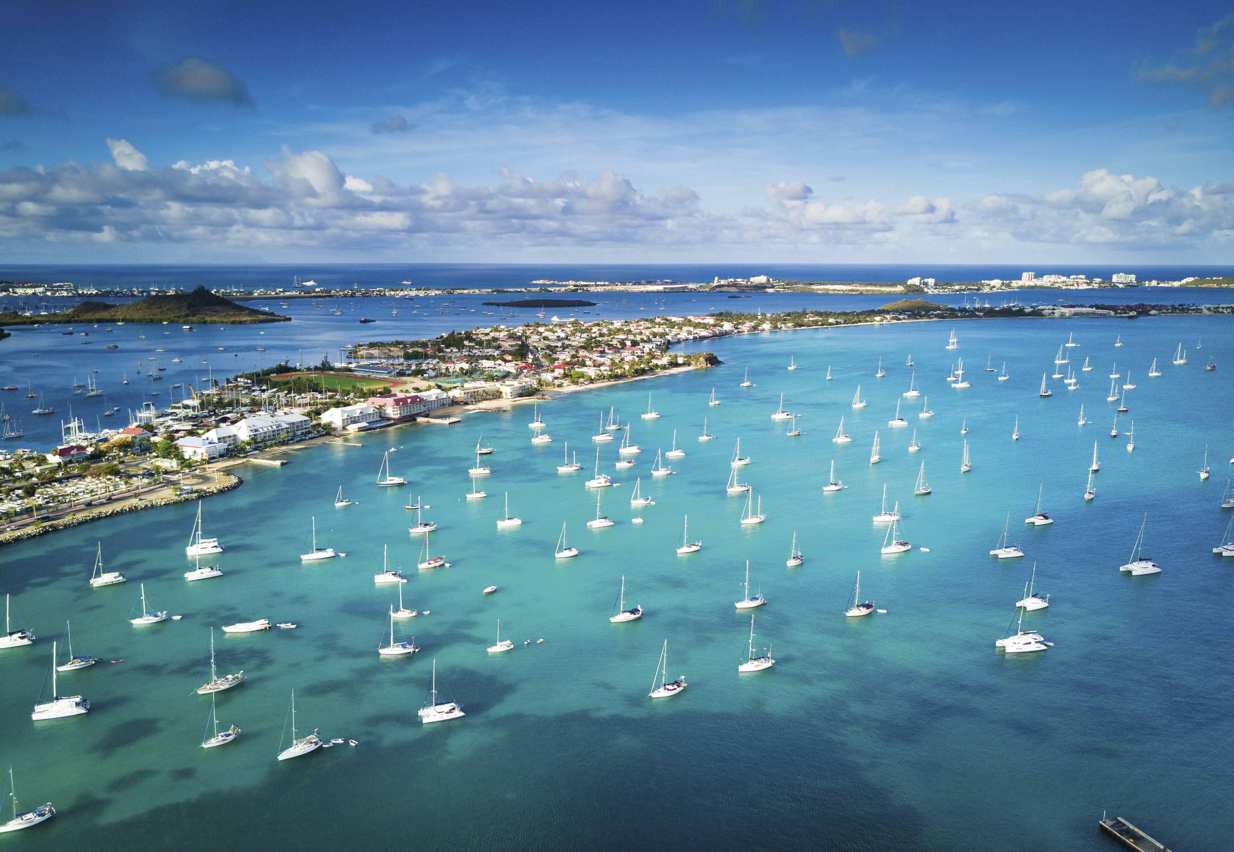 An aerial view of Marigot’s vibrant harbour with turquoise waters and numerous yachts docked in the Caribbean.