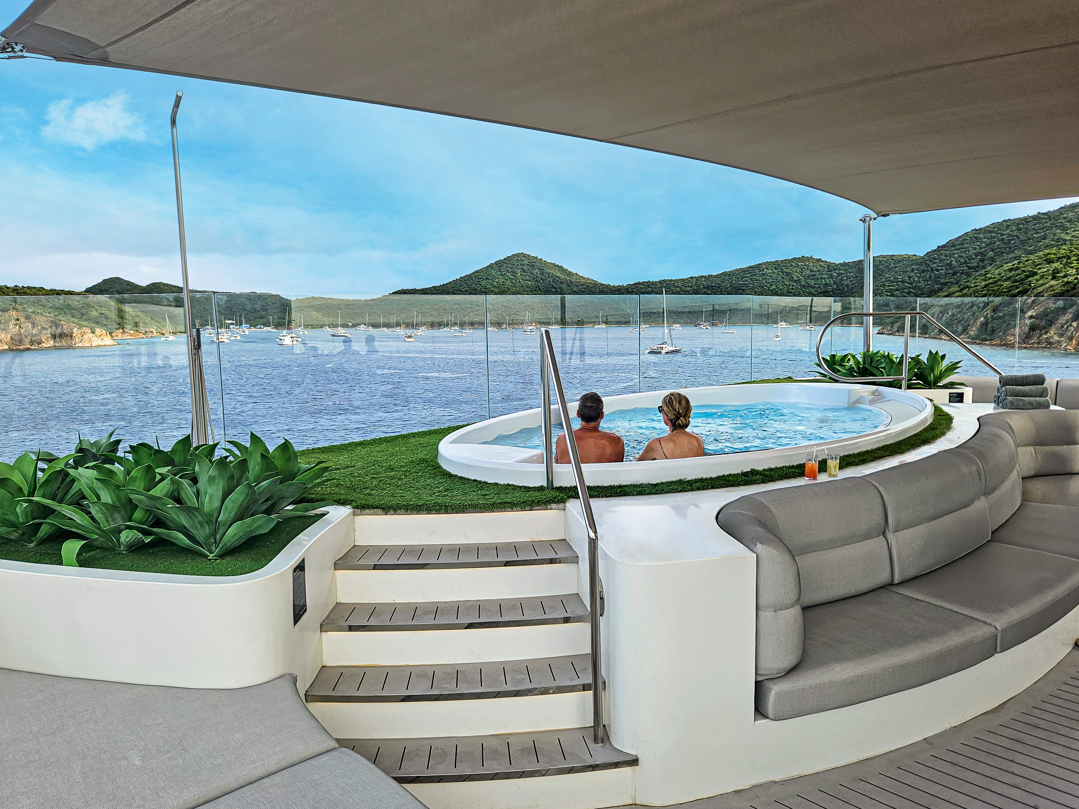 A couple enjoying a tranquil moment in the spa’s outdoor jacuzzi on the Emerald Sakara with scenic coastal views.